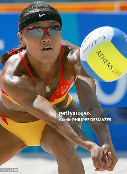 China's Fei Wang returns the ball with partner Jia Tian during the second round beach volleyball match at the 2004 Olympic Games in Athens 16 August...