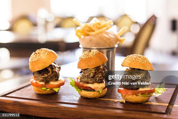 three small hamburgers on a wooden board - aioli stock-fotos und bilder