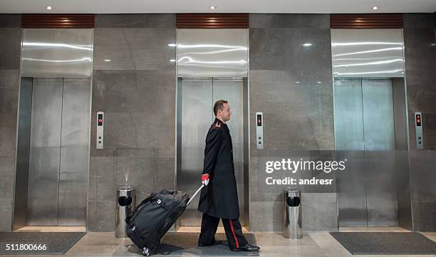 bellboy mit taschen im hotel - hotel page stock-fotos und bilder