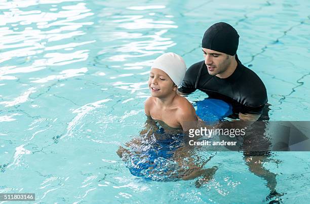 boy taking swimming lessons - hydrotherapy stock pictures, royalty-free photos & images