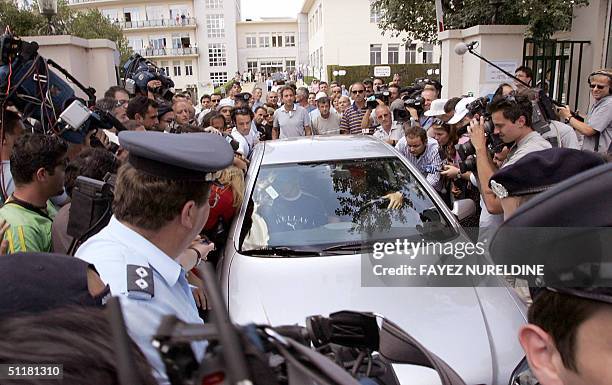 Media and security surround the car carrying Greek athlete Kostadinos Kenteris 17 August 2004 as he leaves the hospital in Athens where he has been...