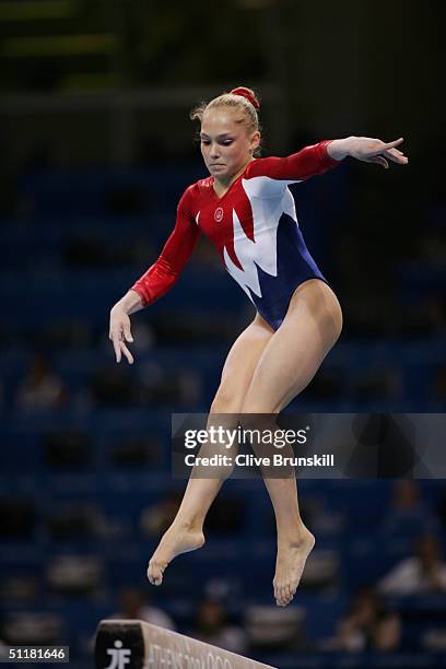 Courtney McCool of the USA performs on the balance beam in the qualification round of the team event at the women's artistic gymnastics competition...