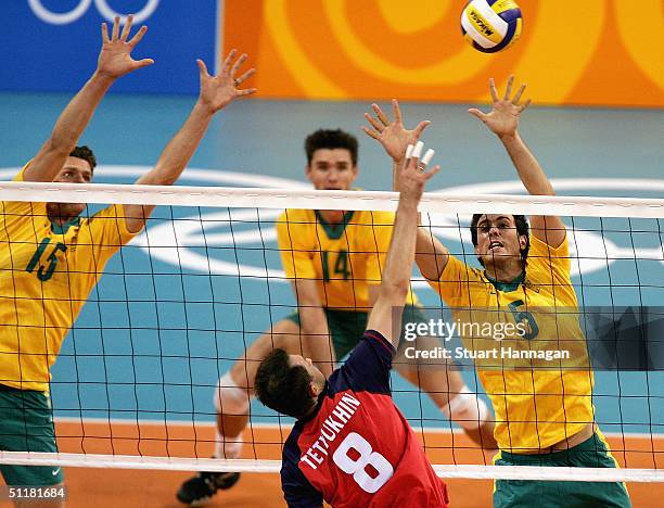 Luke Campbell of Australia defends a spike from Serguey Tetyukhin of Russia during the men's indoor Volleyball preliminary match on August 17, 2004...