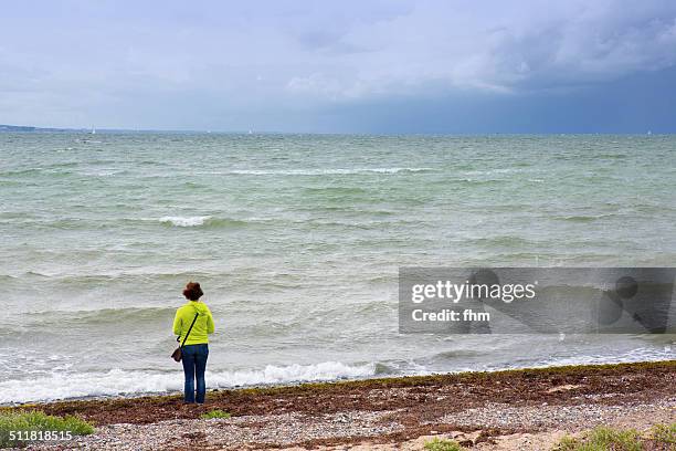 lonely woman on the beach - fehmarn - fotografias e filmes do acervo