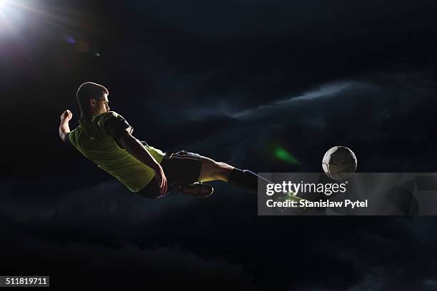 soccer player kicking the ball in the air - soccer skills stock pictures, royalty-free photos & images