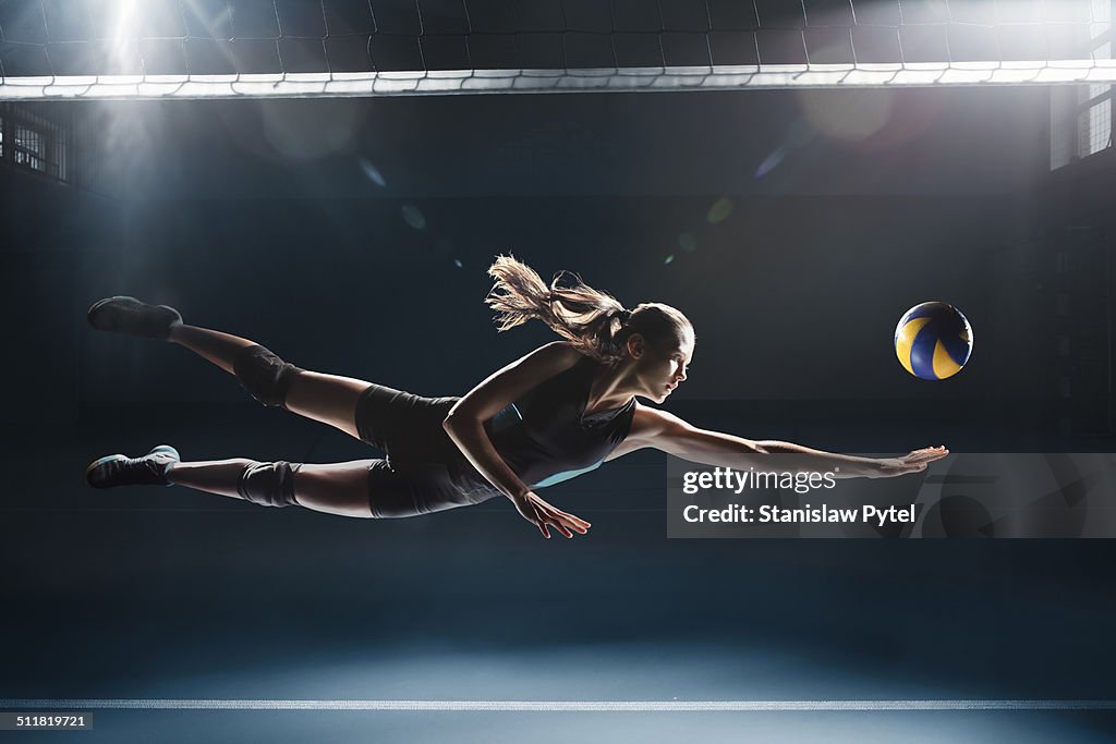 Volleyball player jumping to the ball