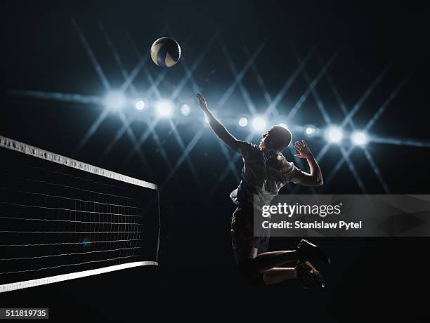 volleyball player jumping to the ball - volleybal stockfoto's en -beelden