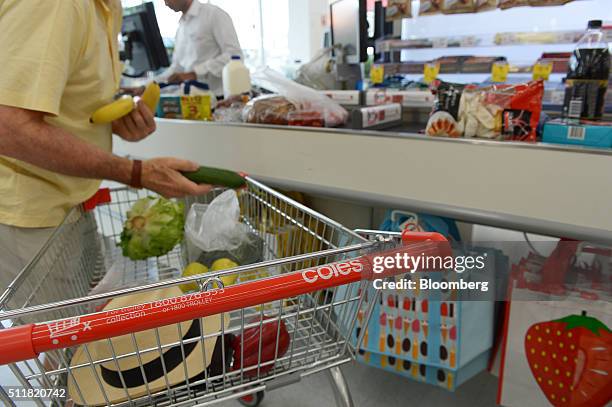 Customer unloads items from his shopping cart at a checkout counter in a Coles supermarket, operated by Wesfarmers Ltd., in Melbourne, Australia, on...