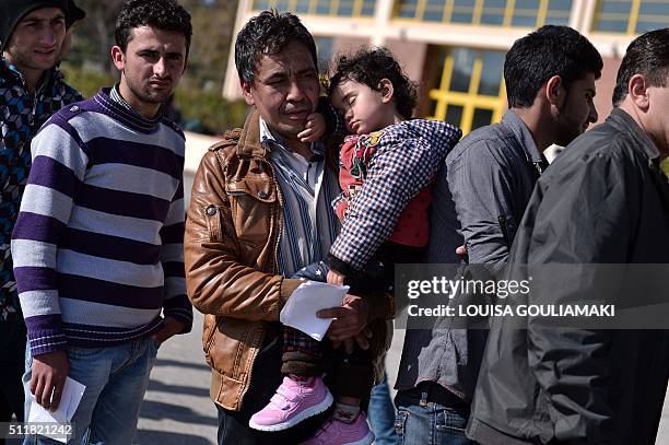 Refugees and migrants queue up to receive some food in the port of Piraeus on February 23, 2016 after their arrival from the islands of Lesbos and...