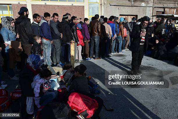 Refugees and migrants queue to receive food distributed by NGO's at the port of piraeus on February 23, 2016 upon their arrival from the Greek...