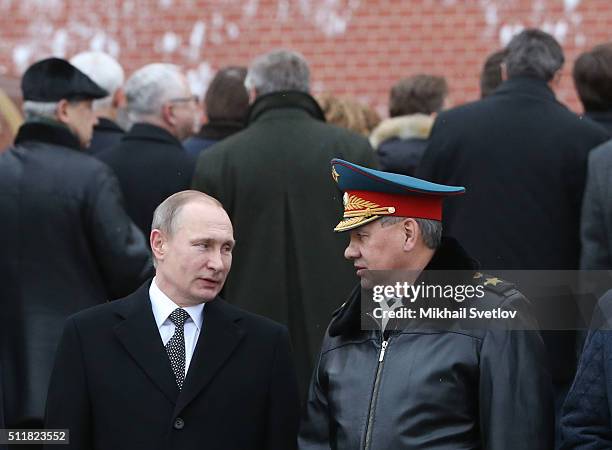 Russian President Vladimir Putin listens to Defence Minister Sergei Shoigi during a wreath laying ceremony at the Unknown Soldier Tomb in front of...