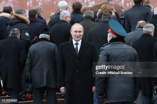 Russian President Vladimir Putin listens to Defence Minister Sergei Shoigi during a wreath laying ceremony at the Unknown Soldier Tomb in front of...