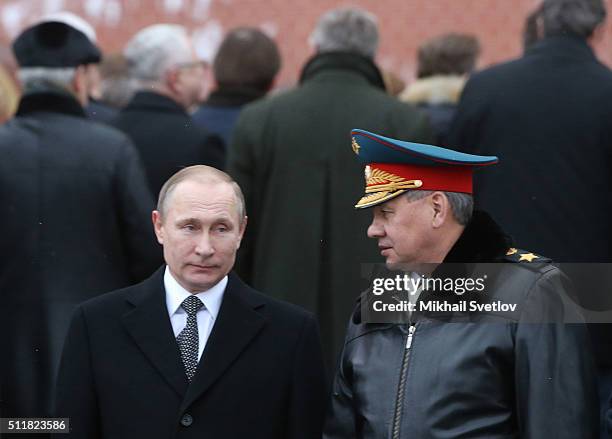 Russian President Vladimir Putin listens to Defence Minister Sergei Shoigi during a wreath laying ceremony at the Unknown Soldier Tomb in front of...