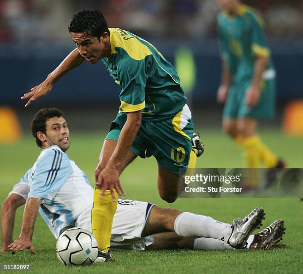 Tim Cahill of Australia skips a challenge from Javier Mascherano of Argentina in the men's football preliminary match between Australia and Argentina...