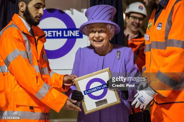 Britain's Queen Elizabeth holds a commemorative plaque after unveiling the new roundel for the Crossrail line that will be known as the Elizabeth...