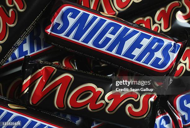 In this photo illustration Snickers and Mars chocolate bars lie on a table on February 23, 2016 in Berlin, Germany. The Mars company, which owns both...