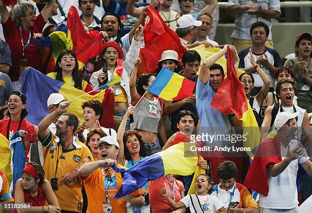 Fans of Romania wave flags in celebration after their team won the gold medal in the women's artistic gymnastics team final competition on August 17,...