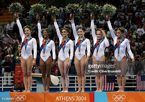 The United States team of Courtney Kupets, Annia Hatch, Terin Humphrey, Carly Patterson, Courtney McCool and Mohini Bhardwaj wave to the crowd after...