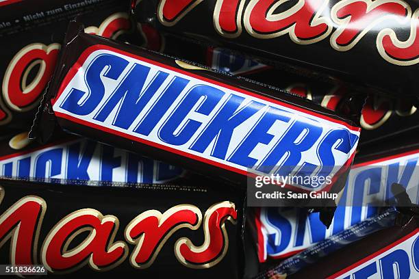 In this photo illustration Snickers and Mars chocolate bars lie on a table on February 23, 2016 in Berlin, Germany. The Mars company, which owns both...