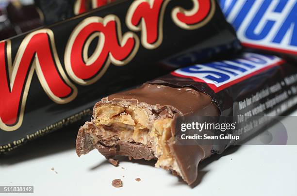 In this photo illustration Snickers and Mars chocolate bars lie on a table on February 23, 2016 in Berlin, Germany. The Mars company, which owns both...