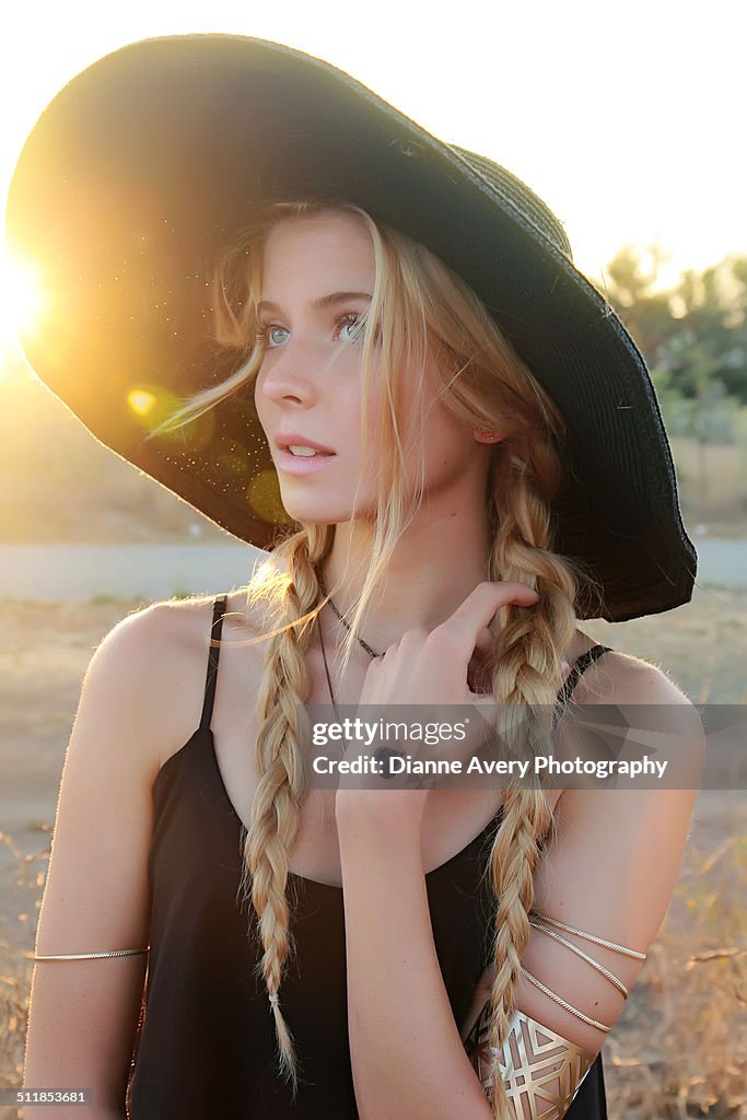 Long blond braids teen girl in field