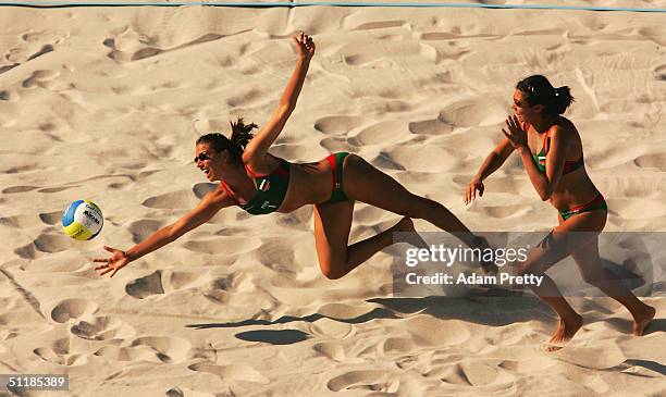 Tzvetelina Yanchulova of Bulagria dives for the ball while teammate and sister Petia Yanchulova looks on during the women's preliminary match between...