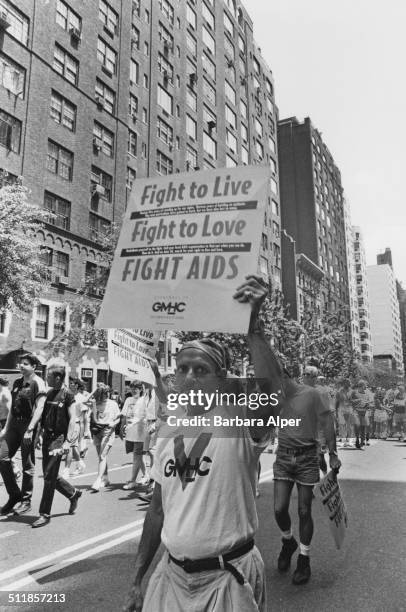 An 'Act Up' march on Fifth Avenue, on the 25th anniversary of the Stonewall Riots, New York City, USA, 26th June 1994. A placard reads 'Fight to...