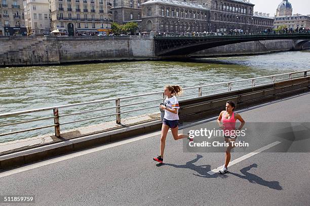 women running in paris along seine - running paris stock-fotos und bilder