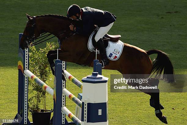 Jean Teulere of France leads his horse Espoir de la Mare over an obstacle in the team three day eventing jumping final competition on August 18, 2004...