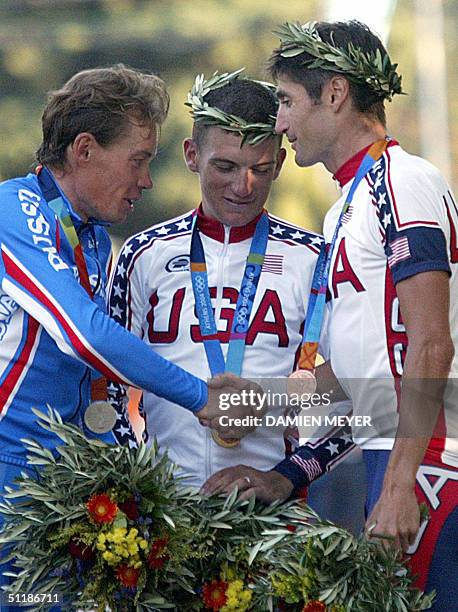 Gold medallist US Tyler Hamilton celebrates on the podium with silver medallist Russian Viatcheslav Ekimov and bronze medallist US Bobby Julich at...