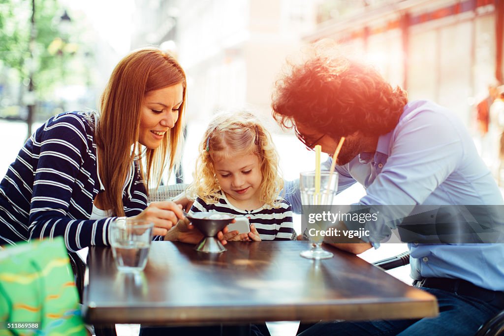 Father And Mother With Their Daughter in Cafe.