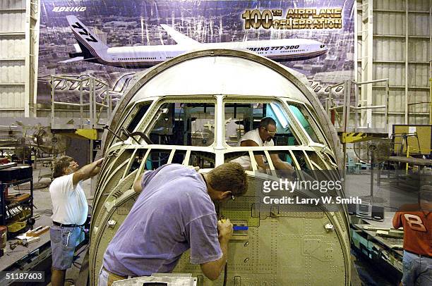 Boeing employee's work on the cockpit of a Boeing 777 at the Boeing Wichita plant August 18, 2004 in Wichita, Kansas. Boeing reportedly is trying to...
