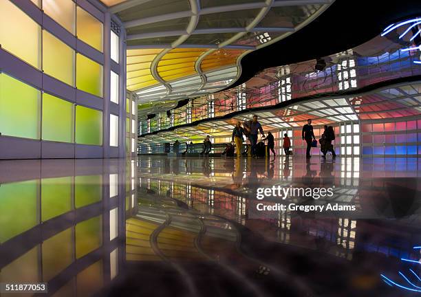 silhouettes of travelers in an airport concourse - ohare airport stock-fotos und bilder