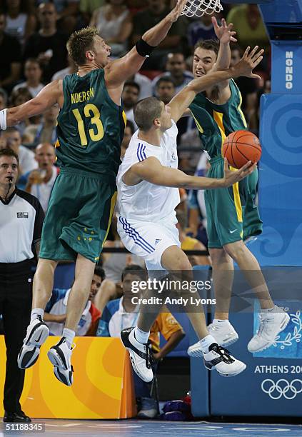Lazaros Papadopoulos of Greece goes to the basket defended by David Anderson and Jason Smith of Australia in the men's basketball preliminary game on...
