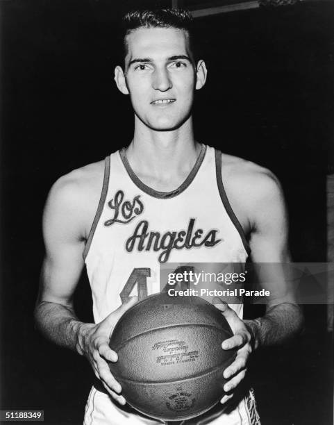 American basketball player Jerry West poses in a Los Angeles Lakers uniform and holds a basketball in his hands, 1960s.