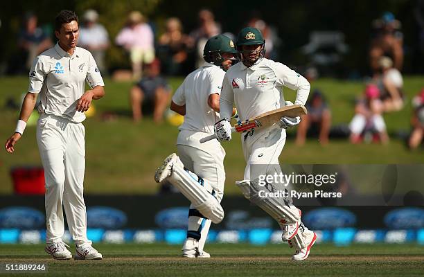 Usman Khawaja of Australia and Joe Burns of Australia run between wickets as Trent Boult of New Zealand looks on during day five of the Test match...