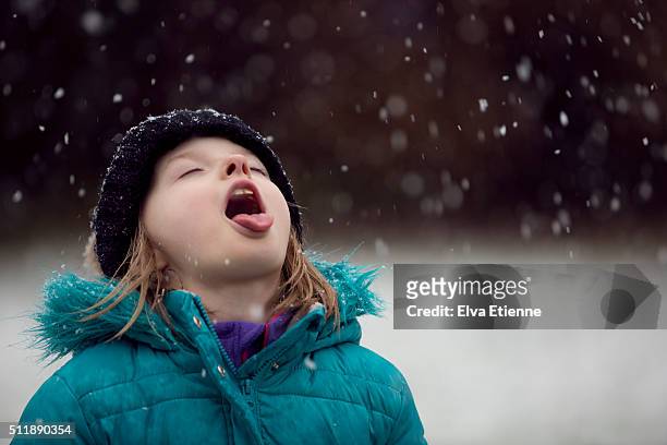 child catching snowflakes on tongue - catching snowflakes stock pictures, royalty-free photos & images