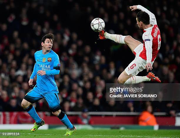 Barcelona's Argentinian forward Lionel Messi watches as Arsenal's French defender Laurent Koscielny jumps to control the ball during the UEFA...