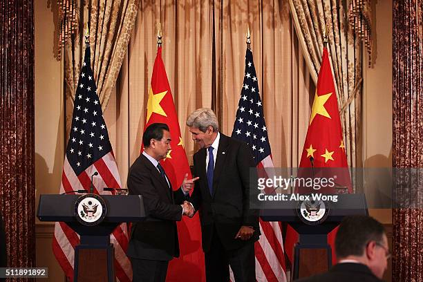 Secretary of State John Kerry and Chinese Foreign Minister Wang Yi shake hands after a joined news conference at the State Department February 23,...