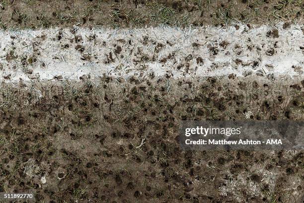 Muddy football pitch with stud marks and a white painted line during the U18 Premier League match between Manchester United and West Bromwich Albion...