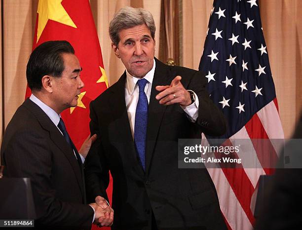 Secretary of State John Kerry and Chinese Foreign Minister Wang Yi shake hands after a joined news conference at the State Department February 23,...