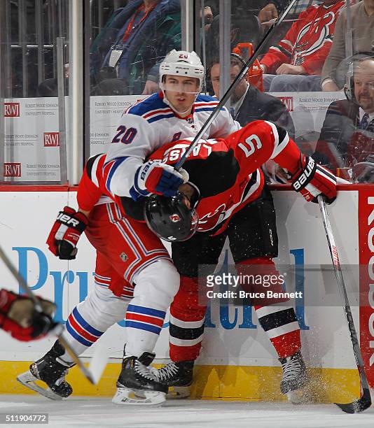 Chris Kreider of the New York Rangers checks Adam Larsson of the New Jersey Devils during the third period at the Prudential Center on February 23,...