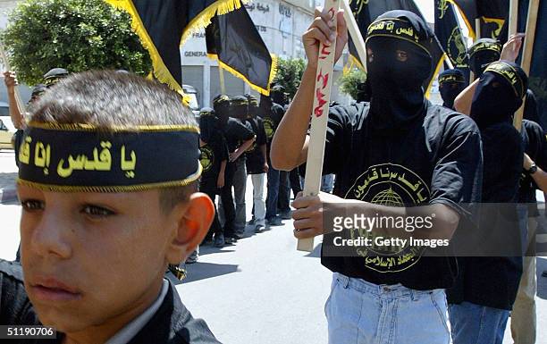 Members of the Palestinian Islamic Jihad movement wear headbands with Arabic writing which reads, ' Jerusalem wait we are coming, Islamic Jihad' as...