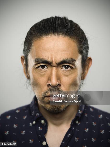 portrait of a japanese man looking at camera. - frowning stock pictures, royalty-free photos & images