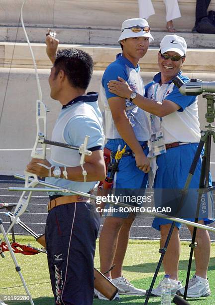 Top ranked Japanese archer Hiroshi Yamamoto, in jubilation, whlie his defeated opponent, world number one Im Dong Hyun from South Korea looks with...