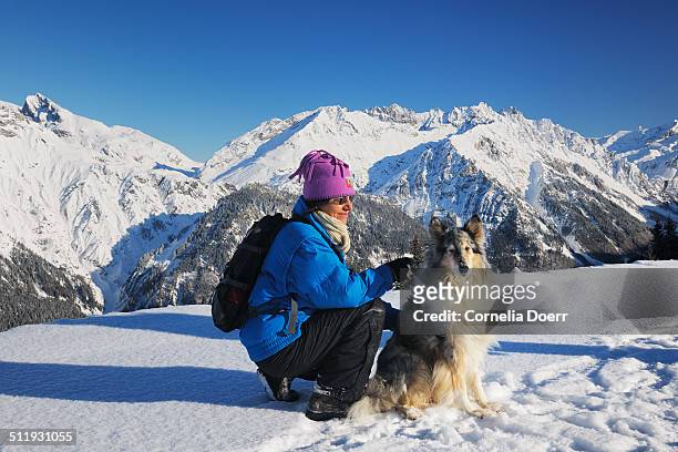 woman enjoying winter day with her dog - sonnenkopf stock pictures, royalty-free photos & images