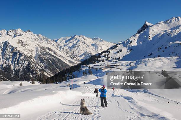 woman enjoying winter hiking with her dog - sonnenkopf stock pictures, royalty-free photos & images