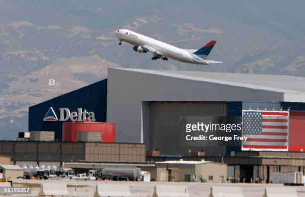 Delta flight takes off over Delta's main hanger at the Salt Lake City International Airport August 19, 2004 in Salt Lake City, Utah. Delta is trying...