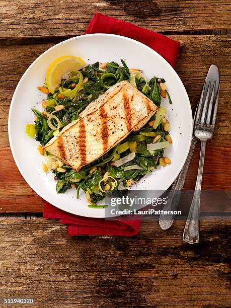 grilled halibut with spinach, leeks and pine nuts - halibut stock pictures, royalty-free photos & images