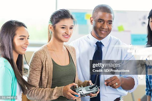 hispanic high school student controls drone in engineering class - radio controlled handset stock pictures, royalty-free photos & images